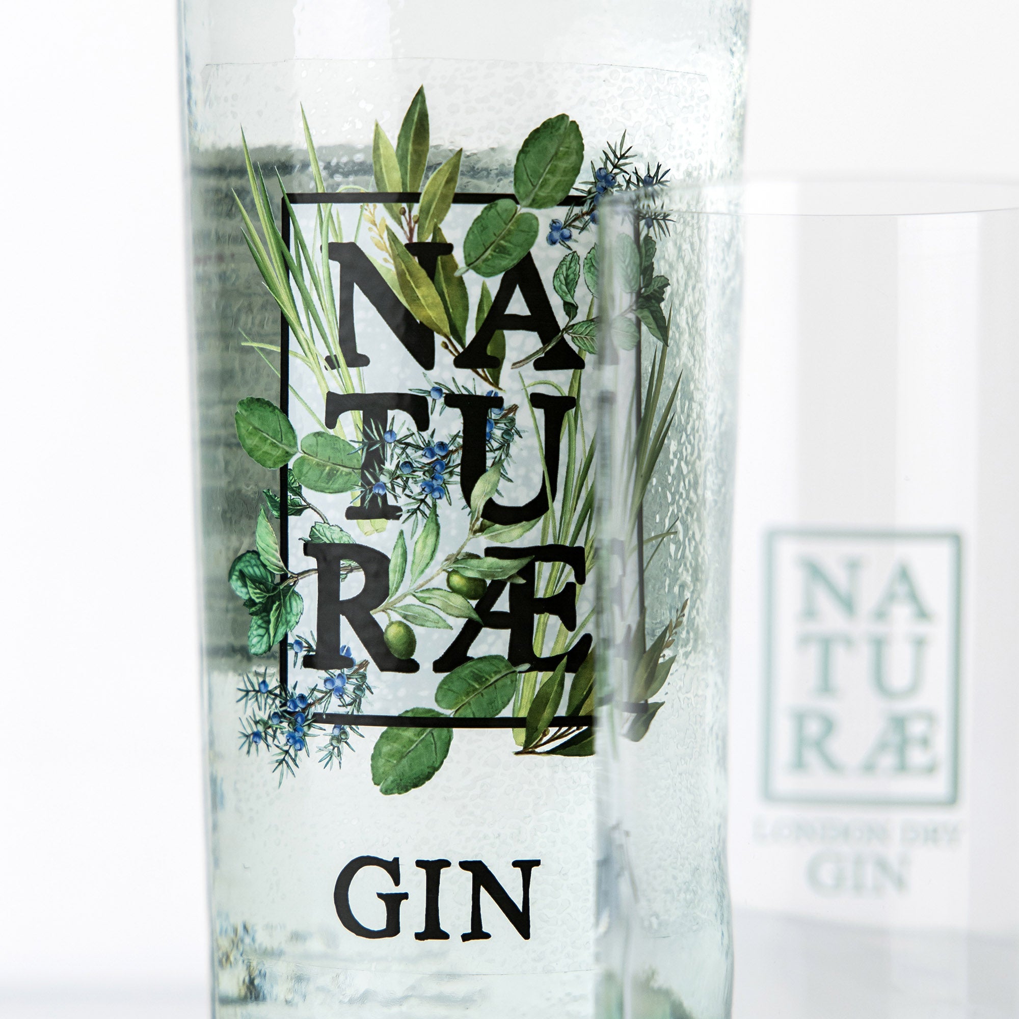 Bottiglia di Naturae Gin Herbarium, distilled gin artigianale con ginepro, menta, lemongrass e foglie d’ulivo, made in Italy. Dettaglio Bottiglia e Bicchiere 